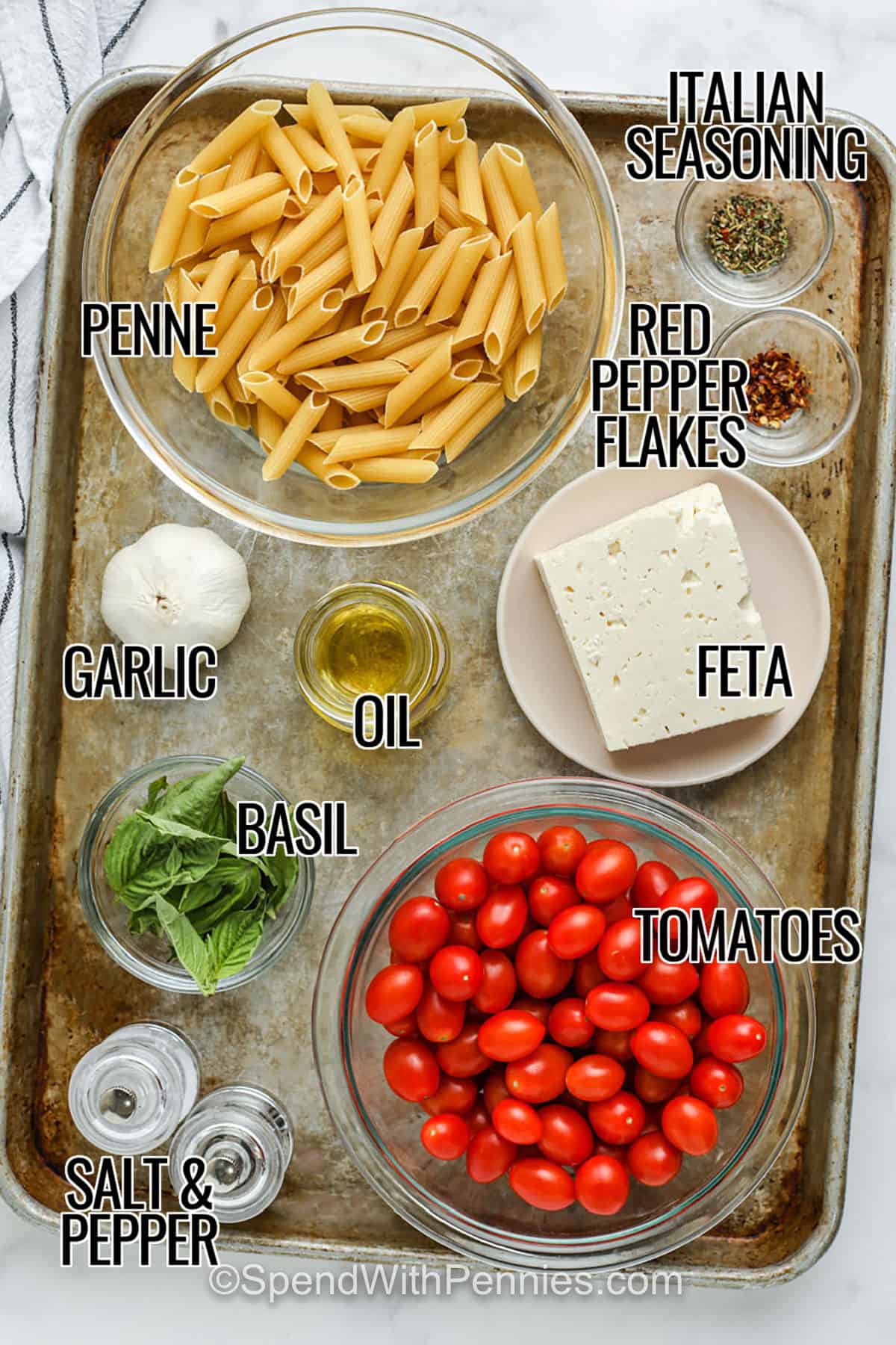 Baked feta pasta is a creamy and flavorful dish that brings together simple ingredients in the best way. Sweet cherry tomatoes are roasted in the oven with garlic and herbs until they burst with flavor, then baked with a block of cheese that melts into a rich sauce. Tossed with pasta, it creates a one-pan recipe that’s both elegant and easy. This vegetarian pasta bake is the kind of comfort food that feels special yet simple enough for any day. #spendwithpennies penne pasta , italian seasoning , red pepper flakes , feta , oil , garlic , basil , tomatoes , salt and pepper with labels to make Baked Feta Pasta