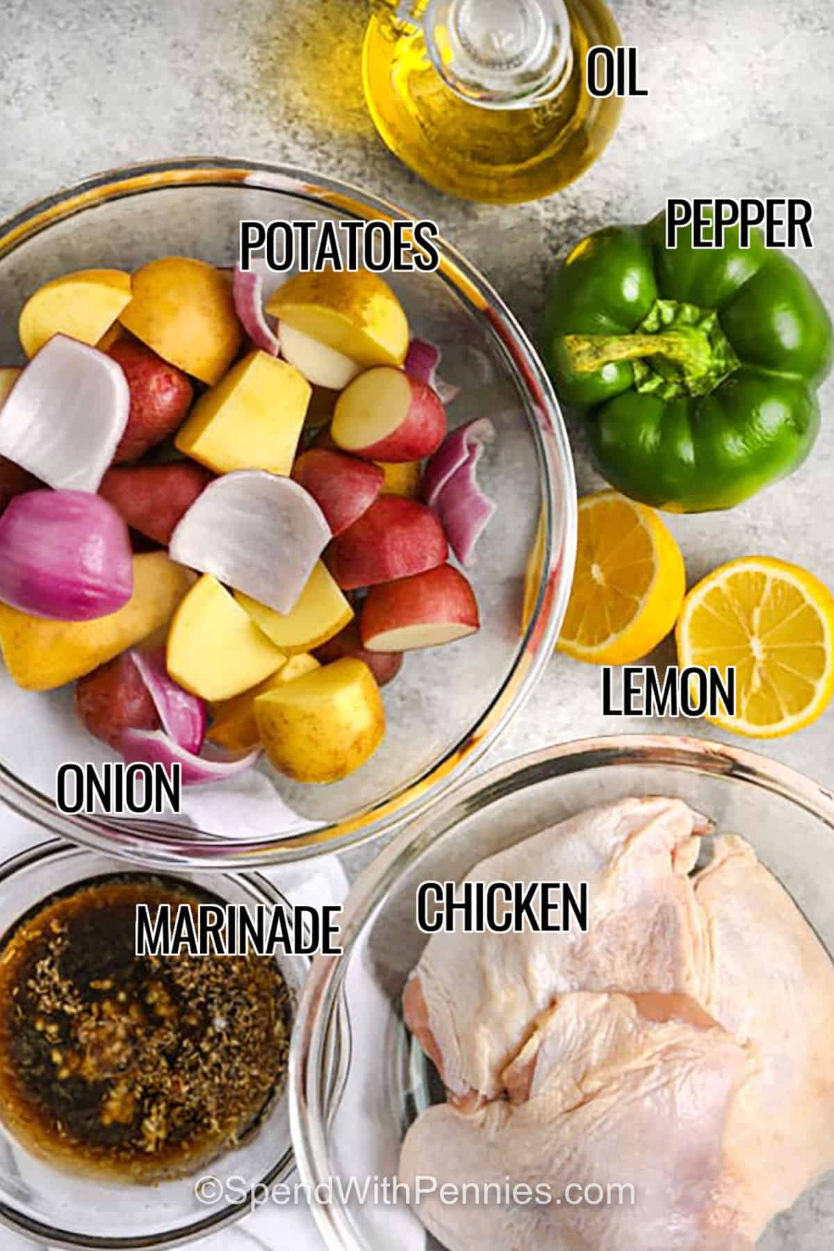 Greek sheet pan chicken is an easy way to get a delicious, wholesome dinner on the table with minimal fuss. Chicken thighs are soaked in a zesty herb marinade, then baked until golden with baby potatoes, onion, bell pepper, and tomatoes. With lemon, rosemary, and oregano with a garnish of feta cheese, this recipe includes all the best Greek flavors. Everything roasts in one pan for easy prep and cleanup. Use thighs with skin and bones intact for the juiciest bites. #spendwithpennies potatoes , oil , pepper , lemon , onion , chicken , marinade with labels to make Greek Sheet Pan Chicken