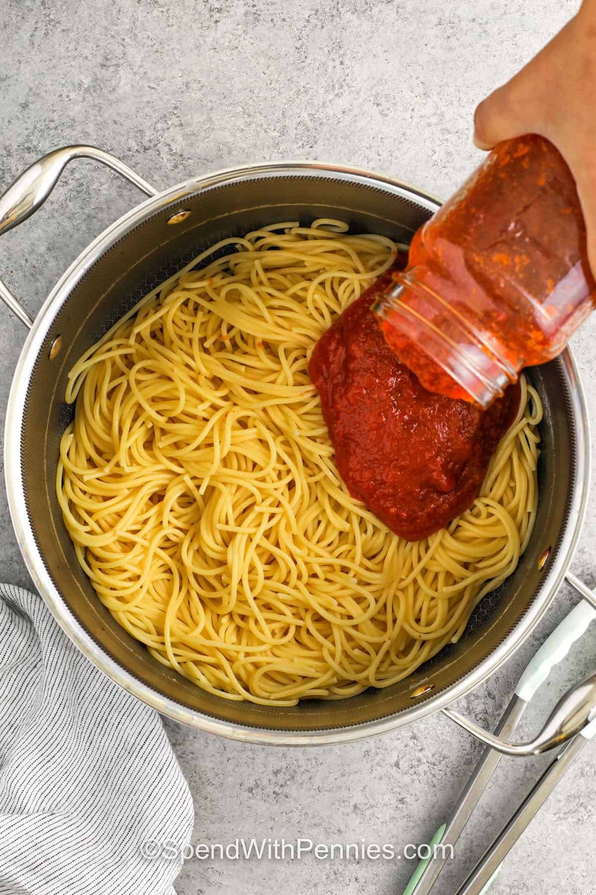 adding sauce to spaghetti to make Million Dollar Spaghetti