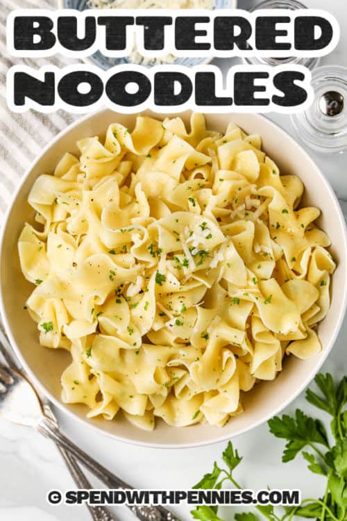 Buttered noodles are the ultimate comfort food, with tender egg pasta coated in melted butter and a touch of garlic powder and other seasonings. This simple stovetop recipe is easy to season just the way you like, with fresh parsley and a sprinkle of Parmesan for richness. Serve it as a plain side or dress it up with your favorite toppings for the best homemade pasta dish that pairs with almost anything. #spendwithpennies plated Buttered Noodles with a title