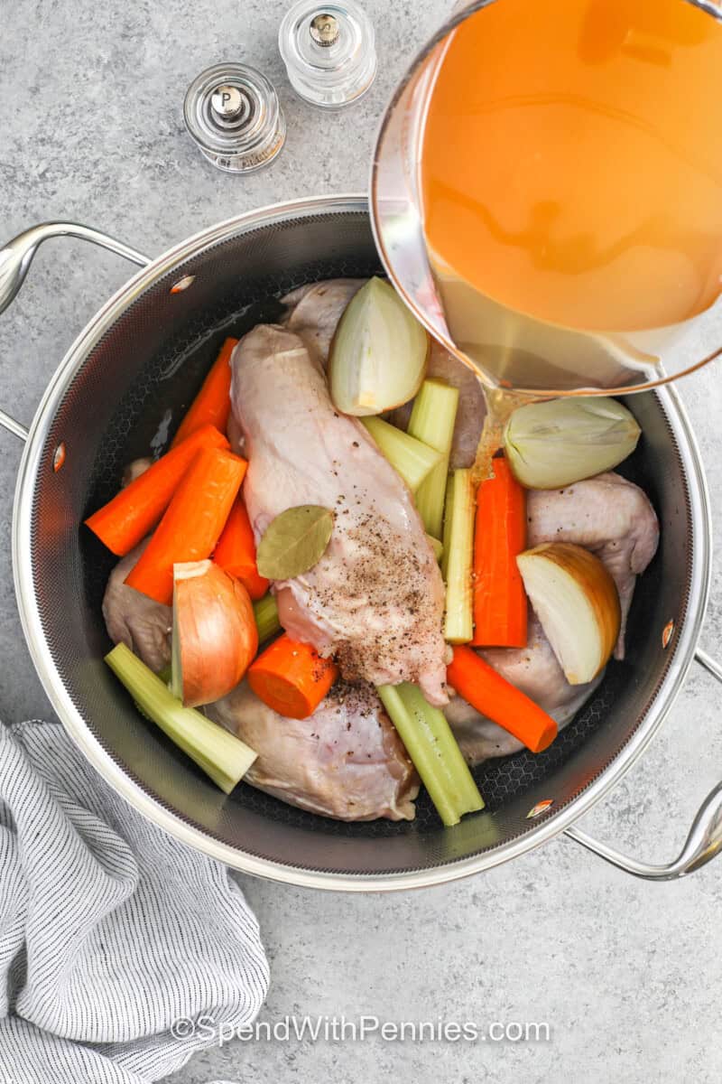 adding broth to chicken and vegetables to make Old Fashioned Chicken and Dumplings