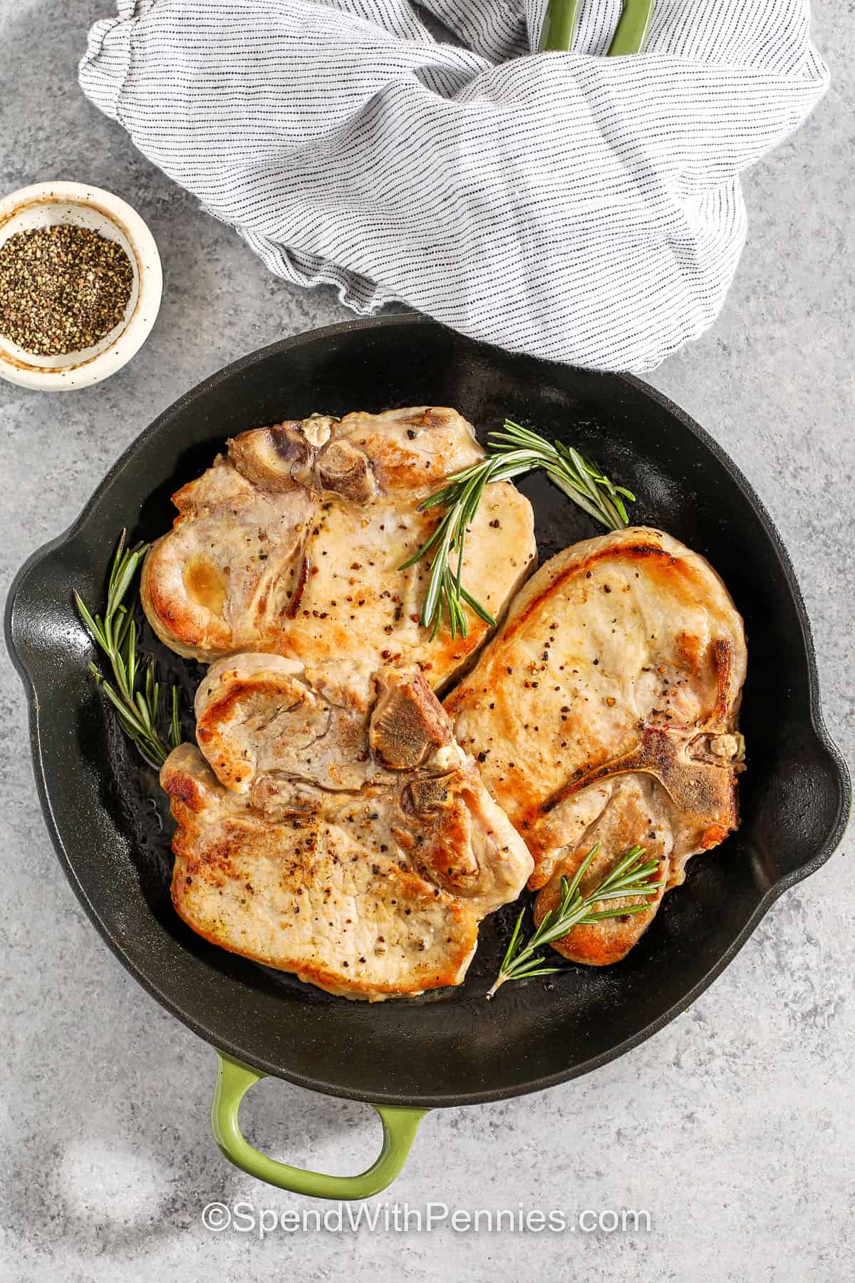 Try this pork chop brine to keep pork tender and juicy every time you cook it. Made with just a few pantry staples like salt, sugar, and rosemary, the brine adds flavor while locking in moisture. After brining, the chops turn out beautifully cooked and ready to serve with any side you love. It’s such an easy recipe, but it makes all the difference for a meal your family will ask for again and again. #spendwithpennies cooked Pork Chop Brine in a pan with rosemary