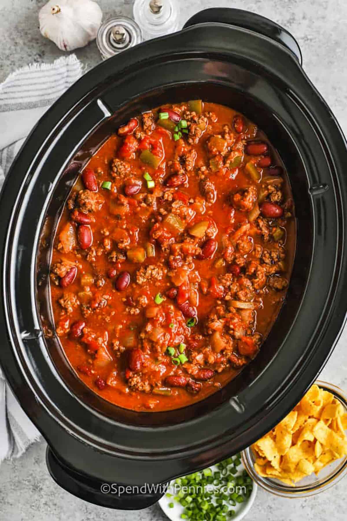 Easy crockpot chili is the ultimate comfort food with rich, hearty flavors and minimal effort. Made with seasoned ground beef, kidney beans, tomatoes, and bold spices, this recipe simmers low and slow in the slow cooker for the perfect texture and depth. Light beer enhances the flavor, and a mix of fresh and canned ingredients adds convenience. Ideal for busy days or meal prep, it's a must-try family favorite. #spendwithpennies hearty Crockpot Chili in the pot