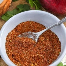 bowl of Taco Seasoning with vegetables and seasonings around the bowl