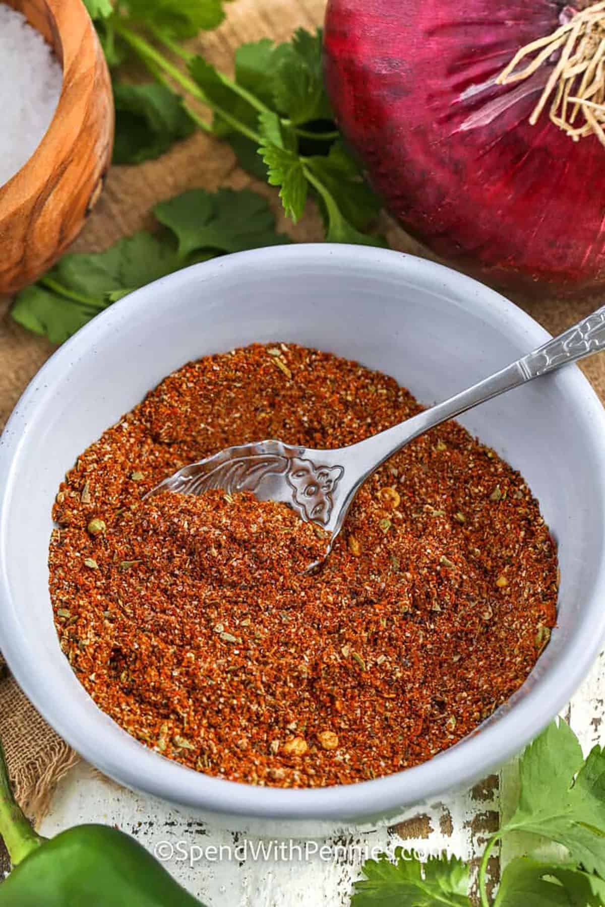 bowl of Taco Seasoning with vegetables and seasonings around the bowl