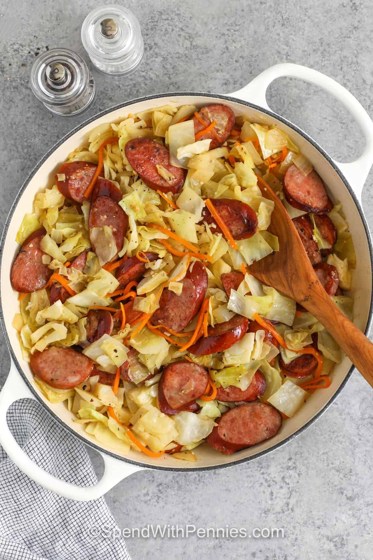 cabbage and sausage prepared in a skillet with a spoon