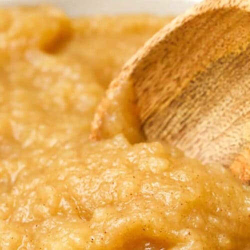 close up of homemade applesauce in a bowl with a spoon in it