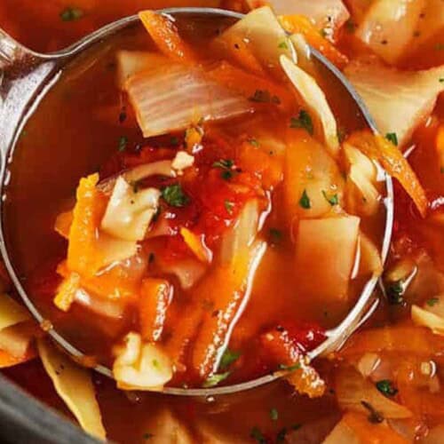 Cabbage soup being ladled in a pot
