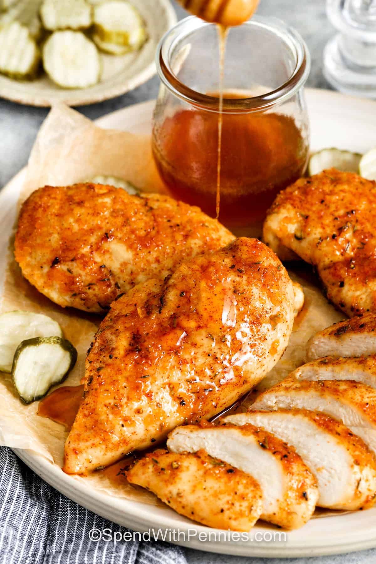 Hot honey chicken is bold, flavorful, and versatile. Juicy chicken is coated in a blend of spices, then brushed with a glaze of hot honey, garlic, and vinegar. The sauce is sticky, tangy, and sweet with just the right amount of spice. Serve this dish as a main course, shred it for a sandwich, or chop it into tenders for a wings-style snack. It also makes the perfect topping for a hearty bowl. #spendwithpennies adding honey to Hot Honey Chicken