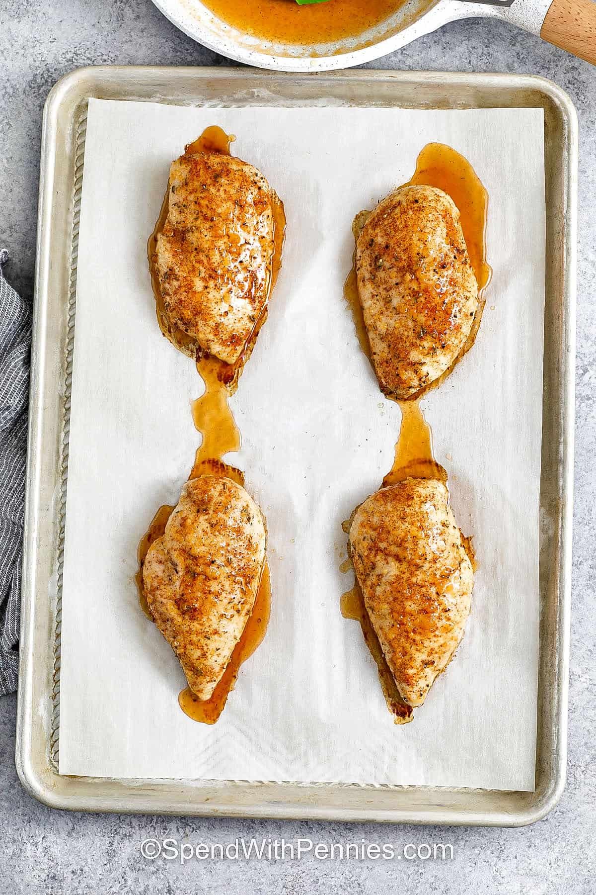 Hot honey chicken is a recipe full of sweet heat and savory flavor. The chicken is baked and finished with a glaze made from hot honey, butter, garlic, and vinegar. The sauce clings to each bite, giving it the perfect balance of spice and tang. Serve this dish alongside vegetables, or slice it up for sandwiches, wings-style bites, or even as a protein for your favorite grain bowl. #spendwithpennies Hot Honey Chicken on a sheet pan before cooking