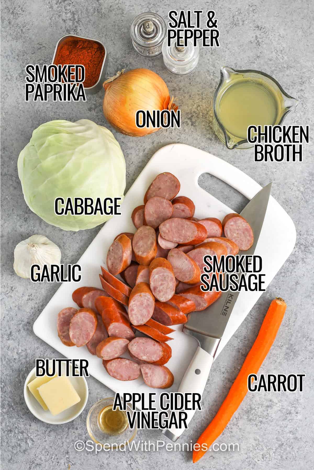ingredients to make cabbage and sausage labeled: salt and pepper, smoked paprika, onion, chicken broth, cabbage, smoked sausage, carrots, apple cider vinegar, garlic, and butter