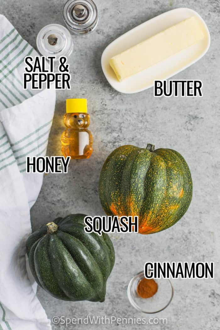 Honey Butter Roasted Acorn Squash ingredients on a table with labeled: salt & pepper, butter, honey, squash and cinnamon