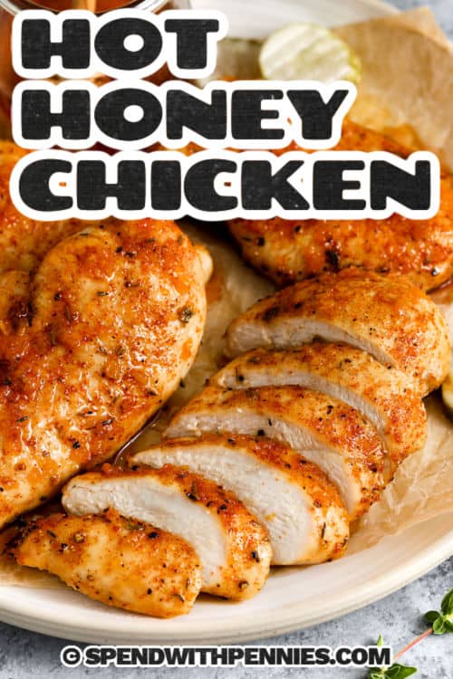 Hot honey chicken is a recipe that’s sweet, spicy, and savory in every bite. Juicy chicken breasts are seasoned, baked, and brushed with a buttery garlic glaze made from hot honey and apple cider vinegar. The sauce is perfectly balanced with heat and tang, making it great for serving whole, sliced into tenders, or tucked into a sandwich. Add it to a fresh salad bowl for a flavorful twist on dinner. #spendwithpennies sliced Hot Honey Chicken with a title
