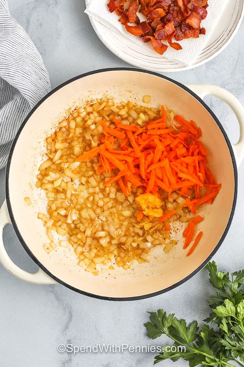 adding carrots and garlic to onions to make Pumpkin Soup