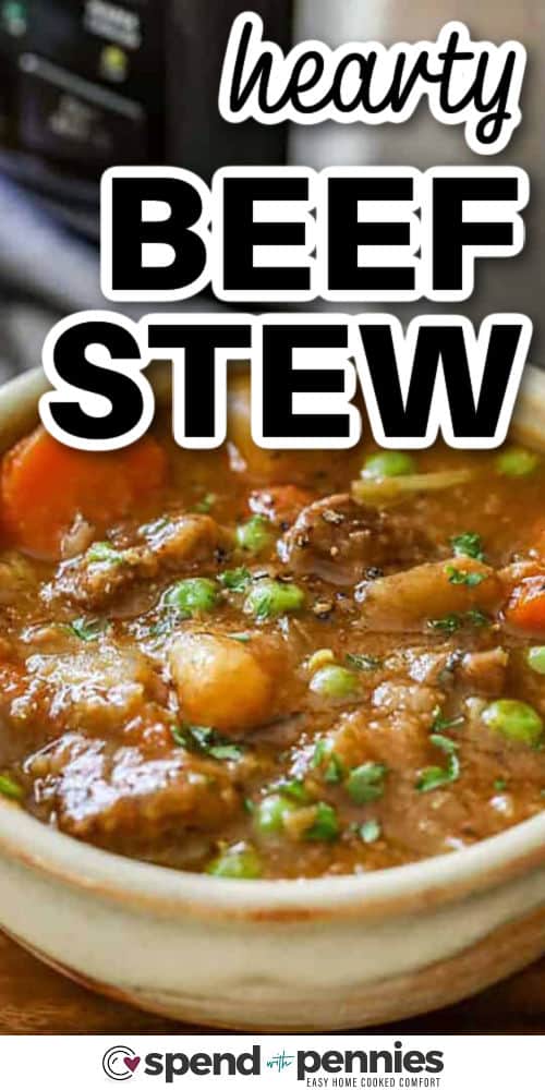 hearty Crockpot Beef Stew in a bowl with crockpot in the back and a title
