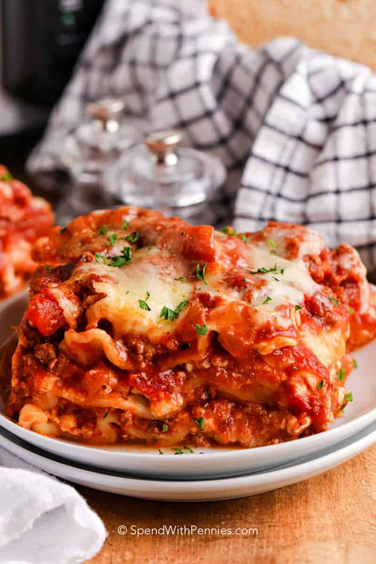 Crockpot lasagna is an easy, hands-off way to make a family favorite. This hearty recipe has all the best parts of lasagna—cheesy layers, rich tomato sauce, and perfectly cooked noodles—without the oven. The slow cooker lets the flavors blend beautifully while keeping it tender and saucy. Serve it with a sprinkle of fresh herbs and parmesan for a comforting meal. #spendwithpennies slice of Crockpot Lasagna on a plate