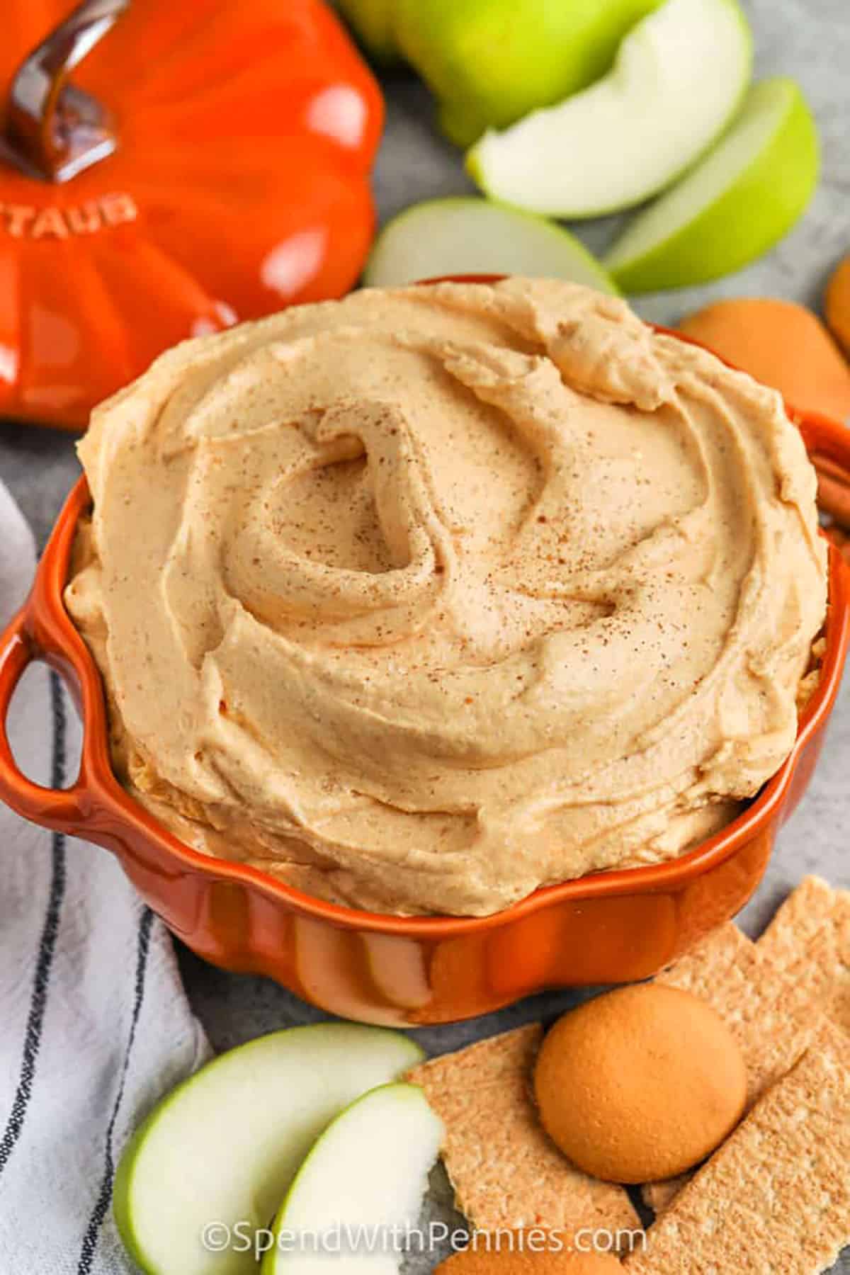 Pumpkin dip has all the flavor of pumpkin pie in a simple recipe. This treat combines cream cheese, pumpkin puree, and pumpkin spice with whipped topping for a smooth, creamy finish. Dunk crisp apples, graham crackers, or even cookies for a dessert that feels cozy and cool at the same time. It is like cheesecake and pudding with a fall-inspired twist, making this dip perfect for parties, game day, or family nights at home. #spendwithpennies bowl of Pumpkin Dip