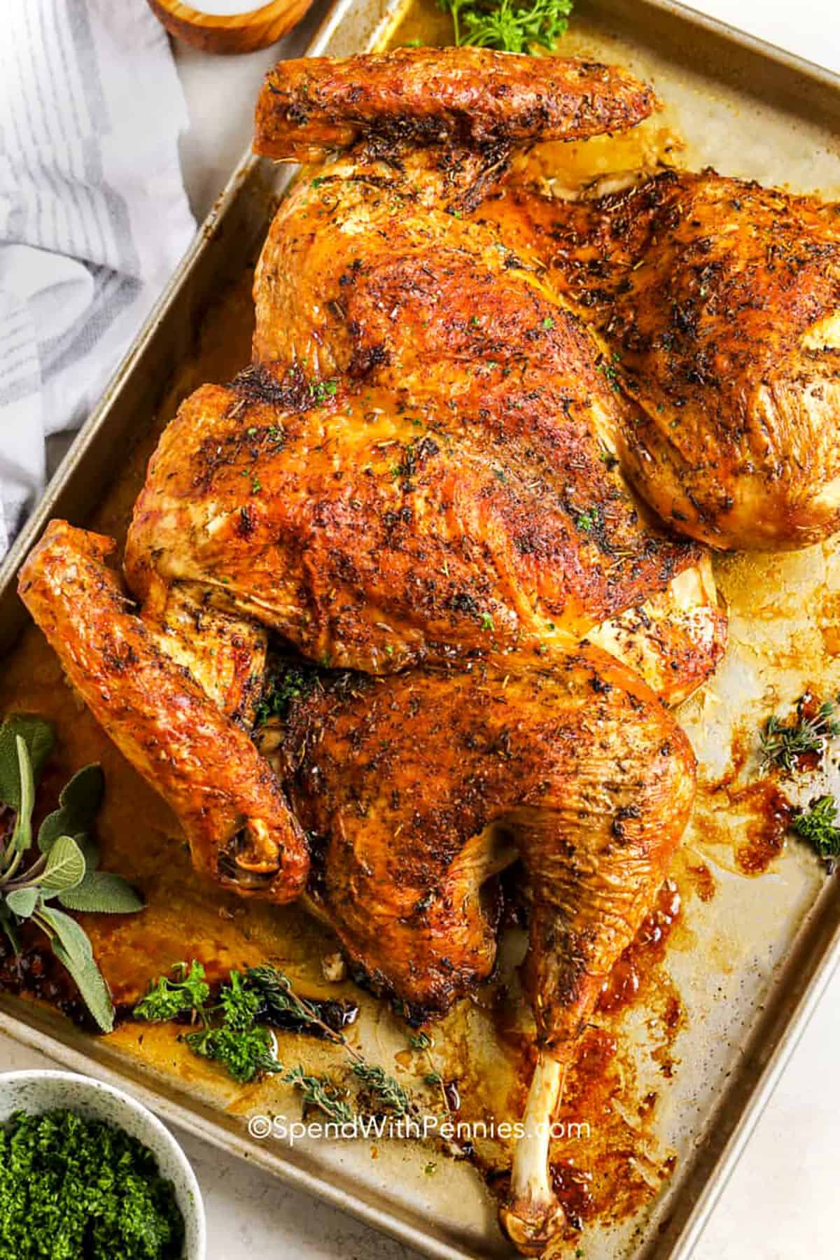 Spatchcock turkey makes your holiday roast easy and foolproof. By cutting out the backbone and laying the bird flat, it cooks evenly and stays juicy all over. Olive oil, herbs, and a little salt and pepper bring out amazing flavor. You can brine the turkey first if you like a little extra moisture and taste. Serve it with gravy made from the pan drippings for a simple, perfect finish. #spendwithpennies Spatchcock Turkey on a sheet pan after cooking