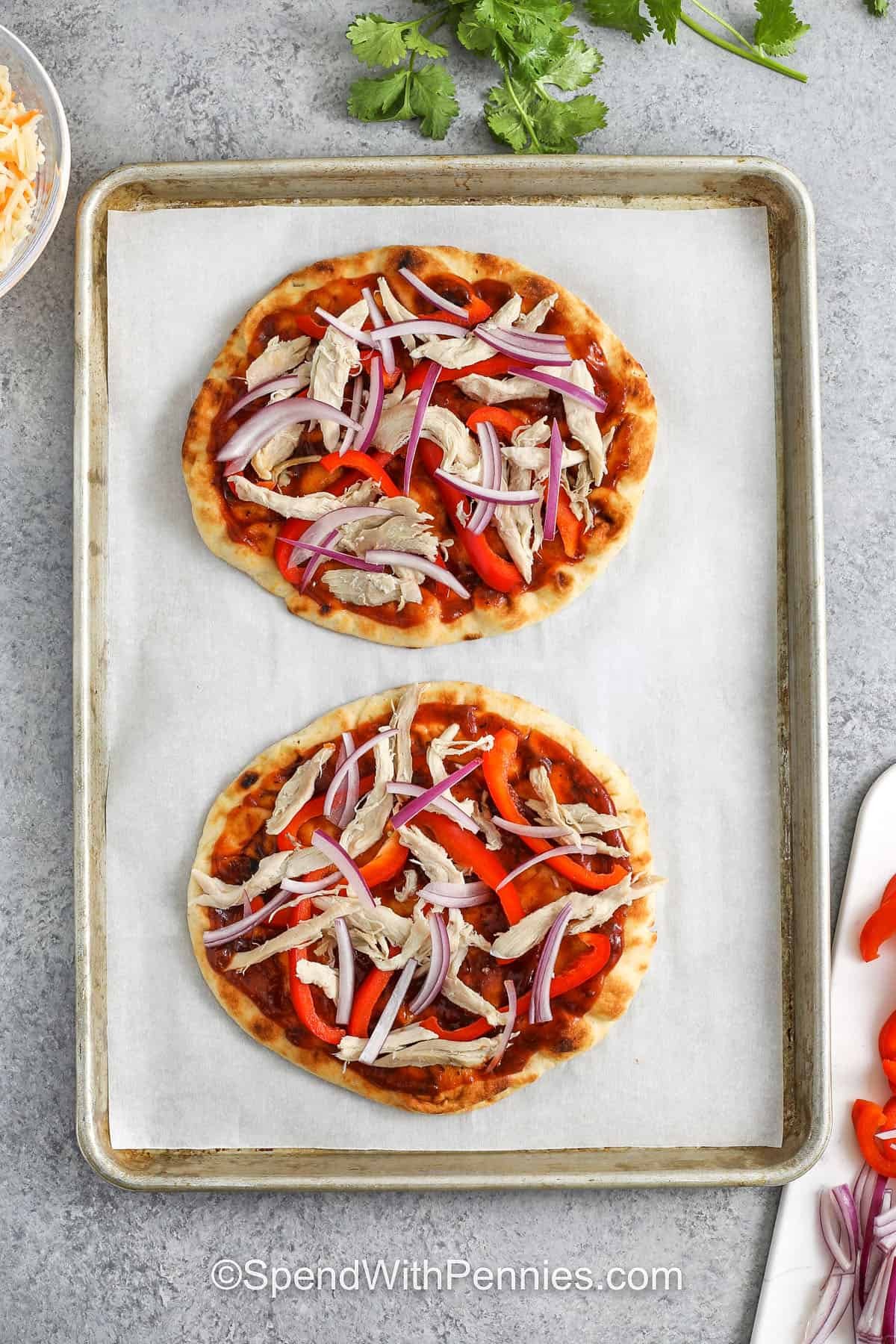 BBQ chicken flatbread is perfect when you’re craving grill-inspired flavor with minimal effort. It combines a tangy BBQ and pizza sauce base with juicy chicken, sweet red bell peppers, and melted cheese, all on crispy naan bread. This better-for-you twist is lower in calories and easy to fit into your healthy eating goals, without sacrificing taste. Fast, fresh, and satisfying! #spendwithpennies adding veggie and chicken to pizza dough and sauce to make BBQ Chicken Flatbread