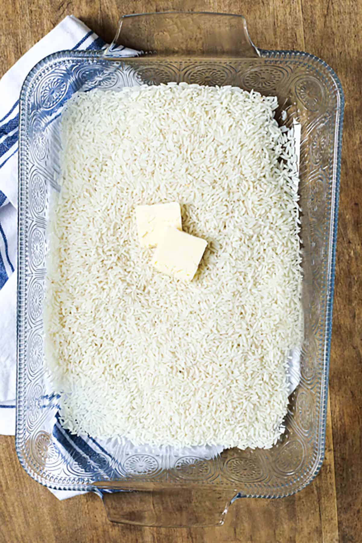 butter on rice in a casserole dish to make Baked Rice