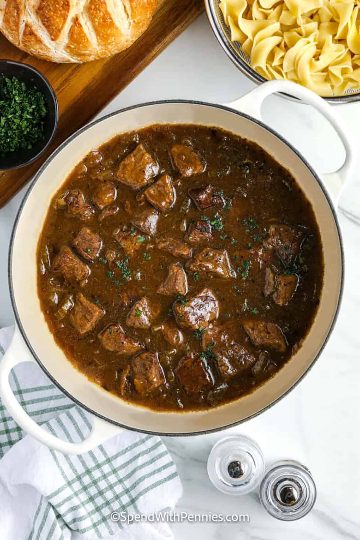 This beef and noodles recipe makes a hearty dish filled with the comforting flavors of beef, egg noodles, and a rich pot of gravy. Onion, celery, and thyme enhance the taste, while the beef becomes tender and flavorful as it cooks. This easy dinner is perfect for busy nights when you want something satisfying but not complicated. Serve it as is or with broccoli or a green salad for balance. Simple and delicious, it is always a hit. #spendwithpennies cooked beef in a pot to make Beef and Noodles Recipe