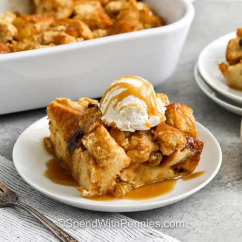 Bread Pudding Recipe with ice cream and jar of caramel sauce beside it with casserole dish full in the back