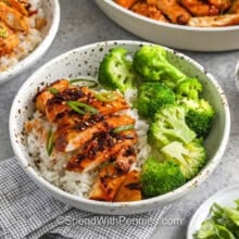 plated Chili Crisp Chicken on rice with broccoli with a jar of chili crips beside it