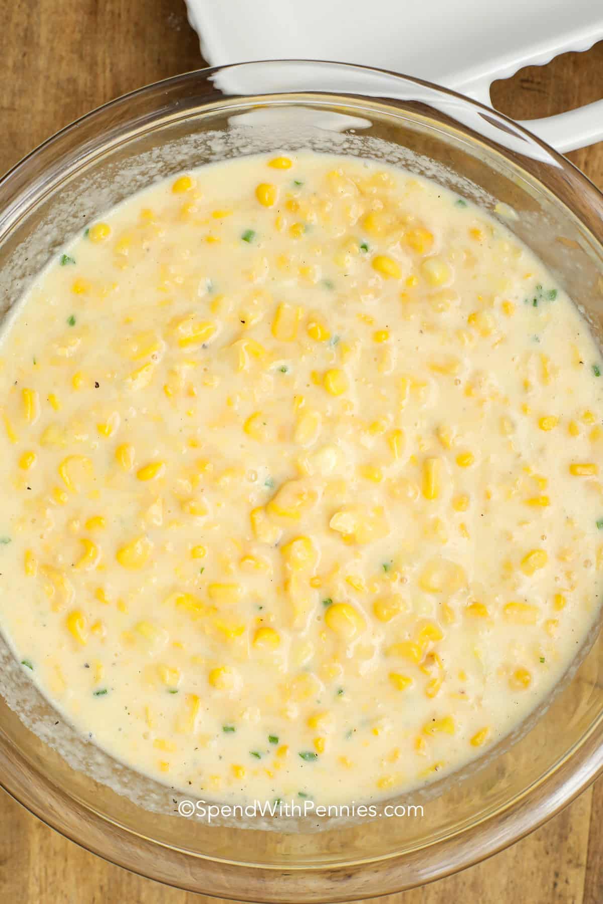 Corn pudding is an easy and comforting classic made with creamed corn, milk, and a hint of sugar. This recipe bakes into a creamy, rich casserole that’s sweet, buttery, and perfectly smooth. Whether you serve it for a weeknight dinner or a big holiday feast, it’s a warm side dish that feels homemade with every spoonful. Try this easy version and enjoy simple southern comfort. #spendwithpennies ingredients mixed in a bowl to make corn pudding
