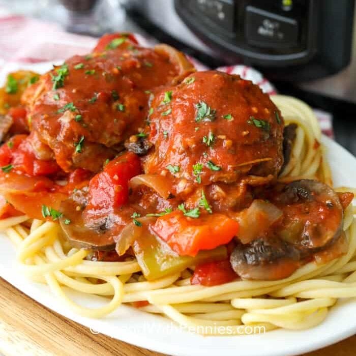 Chicken and vegetables cooked  Cacciatore style on top of spaghetti