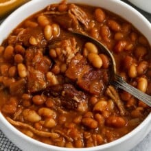 Cropped image of pork and beans in a bowl being served