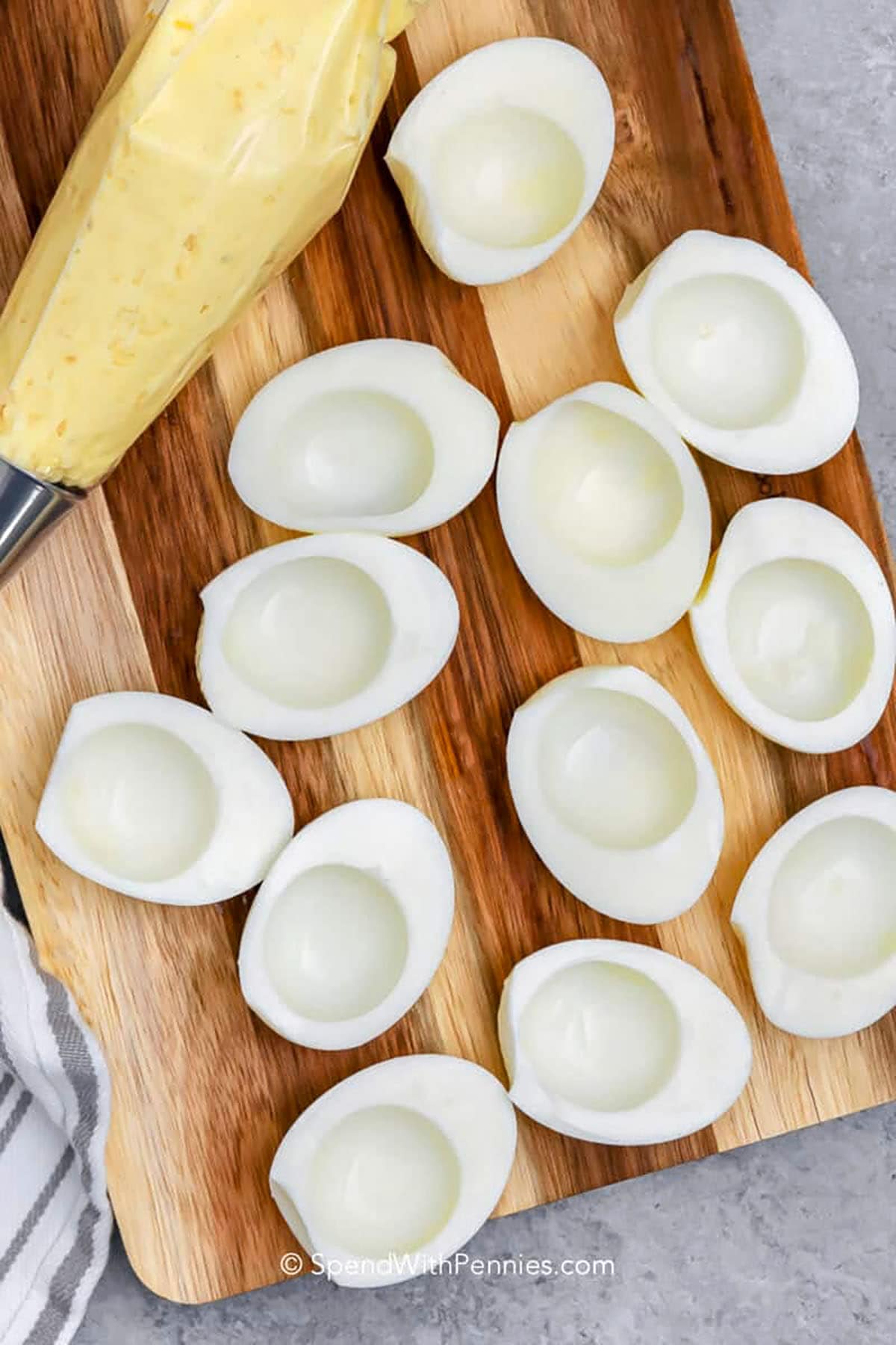 For a festive deviled eggs recipe, this creamy and savory dish is perfect. The yolks are mixed with mayonnaise, mustard, and vinegar for a smooth, tangy flavor, and topped with paprika or bacon for a finishing touch. It is ideal for holiday tables, brunches, or parties. Guests will enjoy how effortlessly it adds flavor and color to the table. #spendwithpennies scooped out eggs to make Deviled Eggs