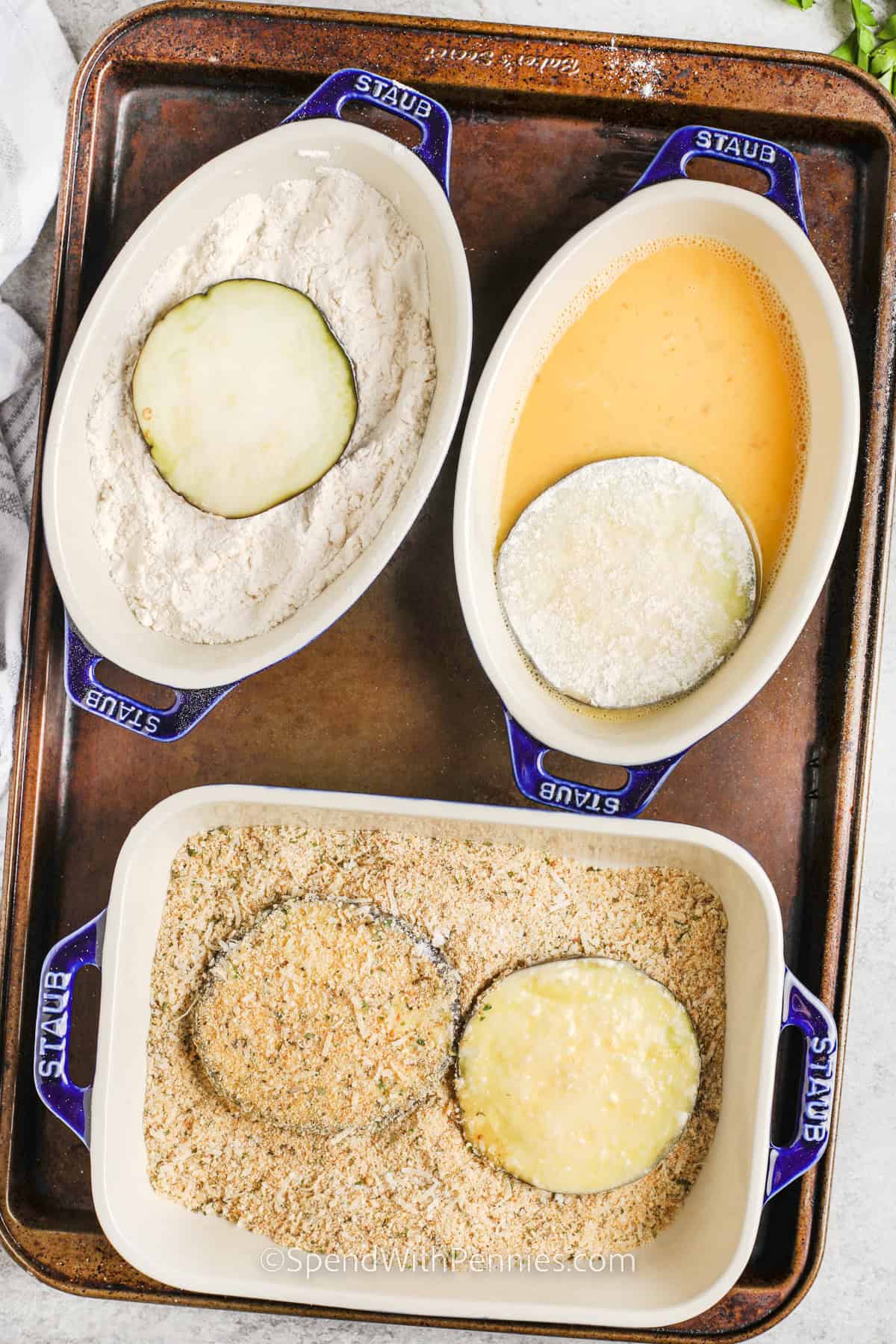 Eggplant parmesan is a healthy twist on a classic dish, layered with baked eggplant, rich marinara sauce, and lots of melted cheese. This easy recipe skips the frying to keep it lighter without losing any flavor. Each bite has savory herbs, golden eggplant, and melty mozzarella mixed with parmesan for the best cheesy finish. Serve it with pasta or salad for a complete dinner the whole family will enjoy. #spendwithpennies process of breading eggplant slices to make eggplant parmesan recipe