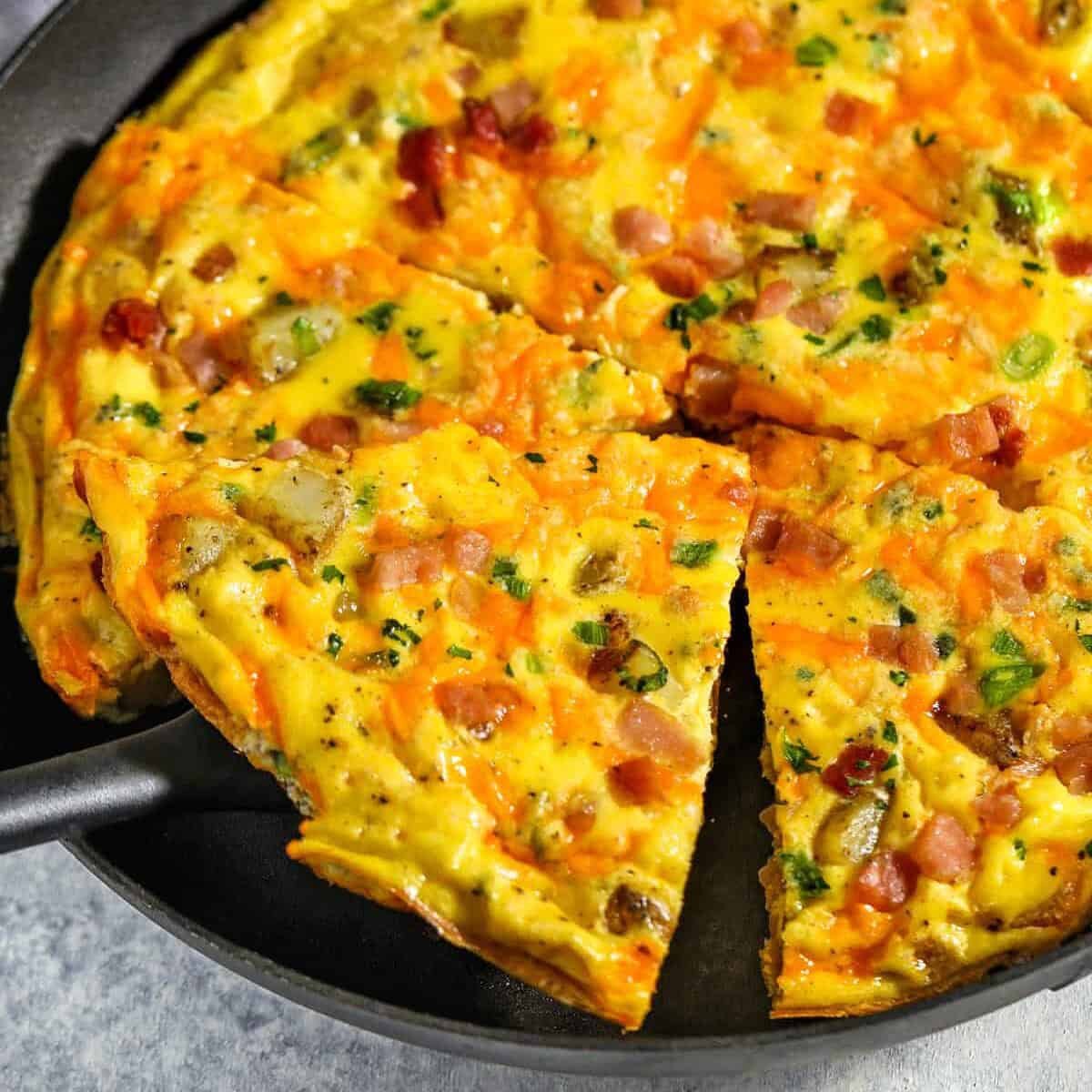 taking a slice of Ham & Cheese Frittata out of the pan