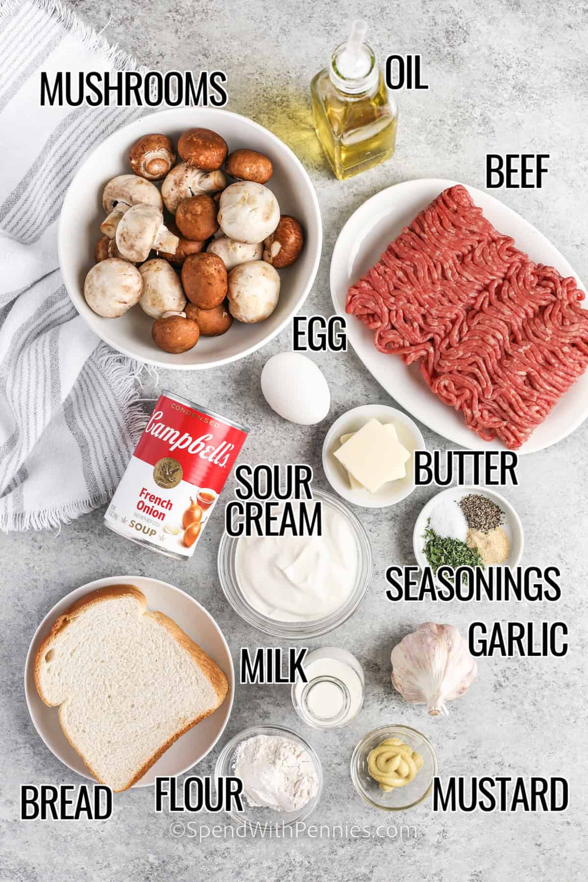 Meatball stroganoff combines hearty beef meatballs and a creamy mushroom sauce for ultimate comfort. The meatballs are seasoned to perfection and browned until golden, then simmered in a rich sauce made from French onion soup, butter, garlic, and sour cream. Serve it over egg noodles for a satisfying dinner everyone will love. Simple, classic, and full of flavor. It is perfect for busy weeknights! #spendwithpennies ingredients to make meatball stroganoff labeled: mushrooms, oil, beef, egg, butter, sour cream, soup, seasonings, garlic, milk, flour, bread, and mustard