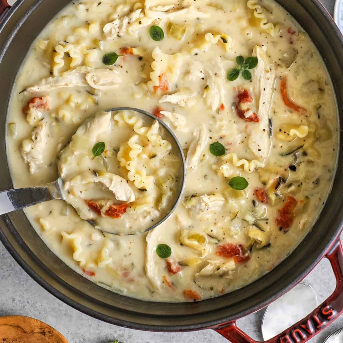 Dutch oven full of white lasagna soup with a ladle