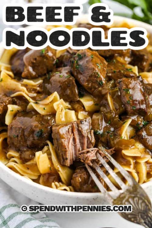 This beef and noodles recipe is a cozy dish with tender beef, egg noodles, and a rich gravy that makes every bite satisfying. Onions, celery, and herbs simmer together with broth to create deep flavor while the beef cooks until fork-tender. Serve it as is or with a side of broccoli for a balanced meal. This easy dinner is perfect for family nights, and it is comfort food at its best with simple ingredients you likely already have. #spendwithpennies bowl of Beef and Noodles Recipe with a fork and a title