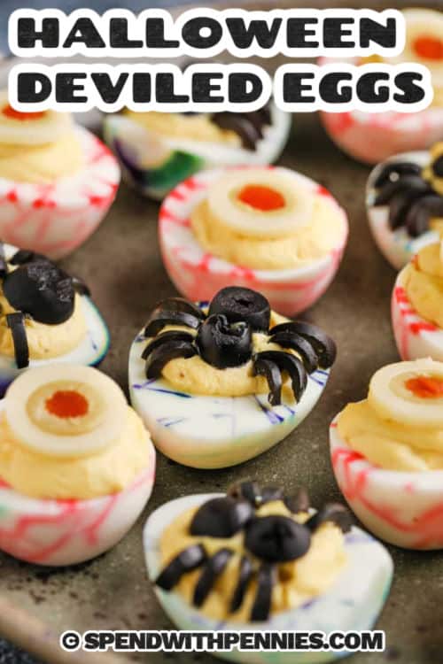 Halloween deviled eggs are a fun, spooky twist on a classic party appetizer. The white of the eggs are marbled with food coloring, and the egg yolk centers have scary spider and eyeball decorations made from olives. You’ll have fun with this crafty recipe and the kids will get a big kick out of making and eating them. Decorate with your own ideas for scary fun. It’s a great eye catching make-and-take snack for costume parties and Halloween gatherings of any kind. #spendwithpennies Halloween Deviled Eggs with a title
