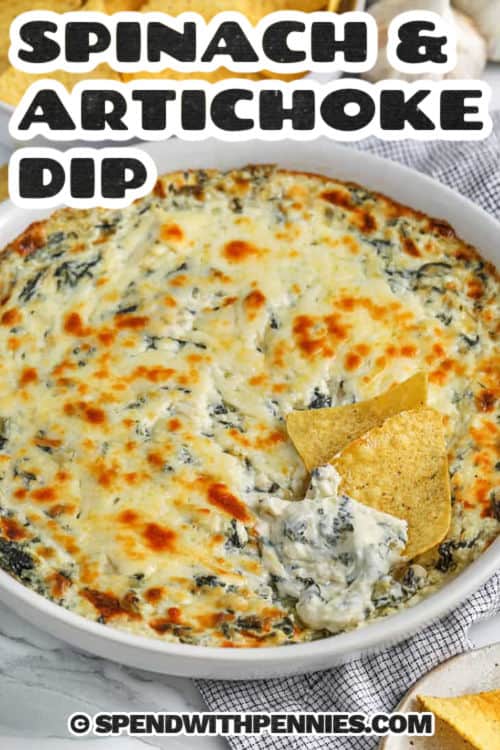 Spinach artichoke dip is rich, creamy, and full of cheesy flavor. This easy recipe blends cream cheese, sour cream, and gooey melted cheese with spinach and marinated artichokes for a warm, comforting appetizer everyone loves. Perfect for dipping bread, chips, or veggies, it’s simple to make and always disappears fast at parties. You can even bake it in a small pot or skillet for easy serving. #spendwithpennies baked spinach artichoke dip with chips dipping and writing