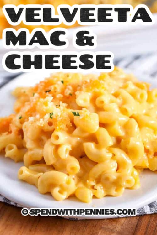 This easy recipe for creamy Velveeta mac and cheese is a crowd-pleasing dish for weeknights or anytime. A homemade Velveeta and cheddar sauce is cooked on the stove top with a hint of mustard and onion powders, then combined with tender elbow macaroni and baked with a crunchy buttered breadcrumb topping. If you’re pressed for time, you can skip the baking and serve from a Crockpot. This tasty recipe beats out mac and cheese from a box any day! #spendwithpennies a scoop of Velveeta mac and cheese on a plate with writing