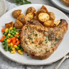 close up of plated Ranch Pork Chops with potatoes and vegetables