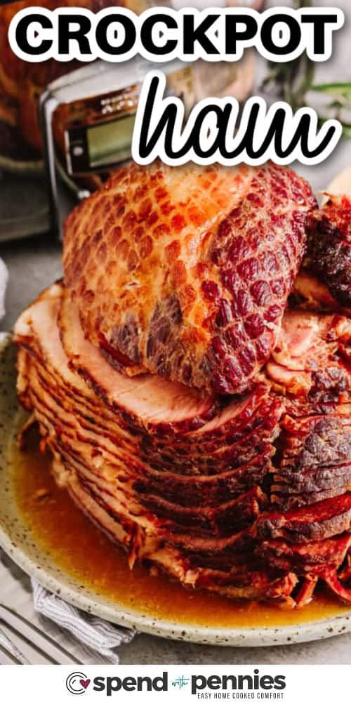 Crockpot ham is a perfect way to make a juicy, flavorful meal without standing over the oven. This spiral ham recipe uses a sweet glaze of brown sugar, apple preserves, Dijon mustard, and a touch of ginger to add depth. Cook in your slow cooker and optionally add rosemary for aroma. Pair it with roasted potato wedges, warm soup, or a side of baked beans for a complete comfort meal that the whole family will enjoy. #spendwithpennies sliced crockpot ham with a crockpot in the background, with writing