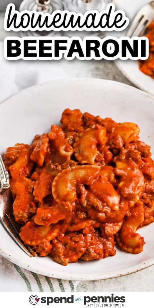 Homemade beefaroni is the perfect mix of pasta, beef, and creamy tomato sauce made all in one skillet. This recipe uses simple pantry ingredients and delivers bold flavor with minimal effort. Cream cheese melts into the sauce, creating a rich, smooth texture, while cheddar adds a cheesy finish. Ideal for weeknight dinners when time is short but appetites are big. #spendwithpennies beefaroni in a bowl with a fork and writing