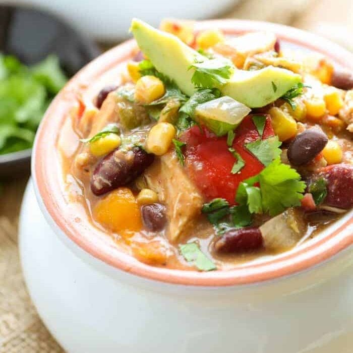 Slow Cooker Chicken Chili in a bowl with cilantro and avocado