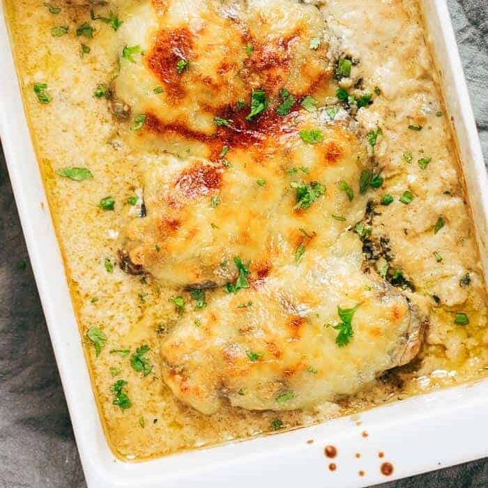 Creamy spinach artichoke chicken casserole straight out of the oven in a white baking dish