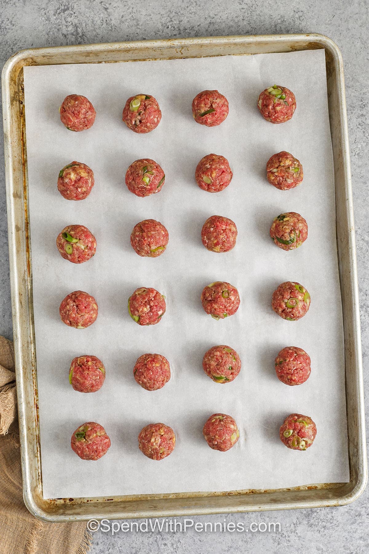 prepared uncooked meatballs on a baking tray for teriyaki meatballs