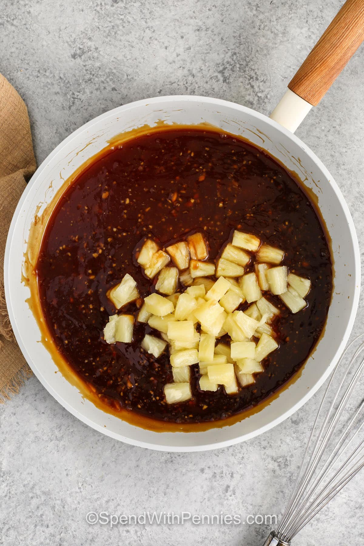 adding pineapple bits to sauce for teriyaki meatballs