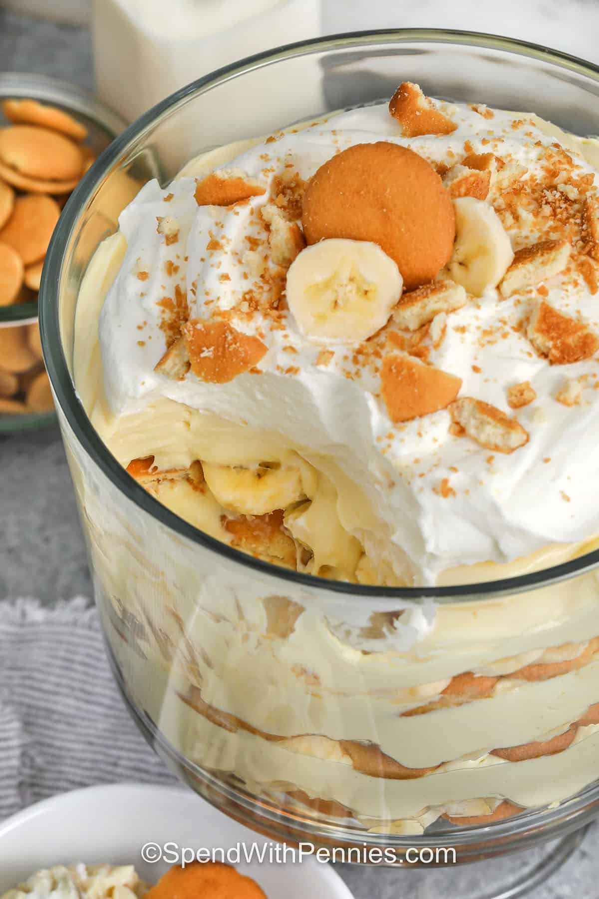 This banana pudding recipe is an easy dessert that everyone loves. It’s made with creamy vanilla pudding, ripe bananas, and layers of Nilla wafers topped with sweet whipped cream. The mix of cream cheese and milk makes it smooth and rich, while the wafers soak up all that delicious flavor. It tastes like banana cream pie but with a lighter touch. Simple to make, pretty to serve, and gone in no time. #spendwithpennies close up of Banana Pudding with a part missing