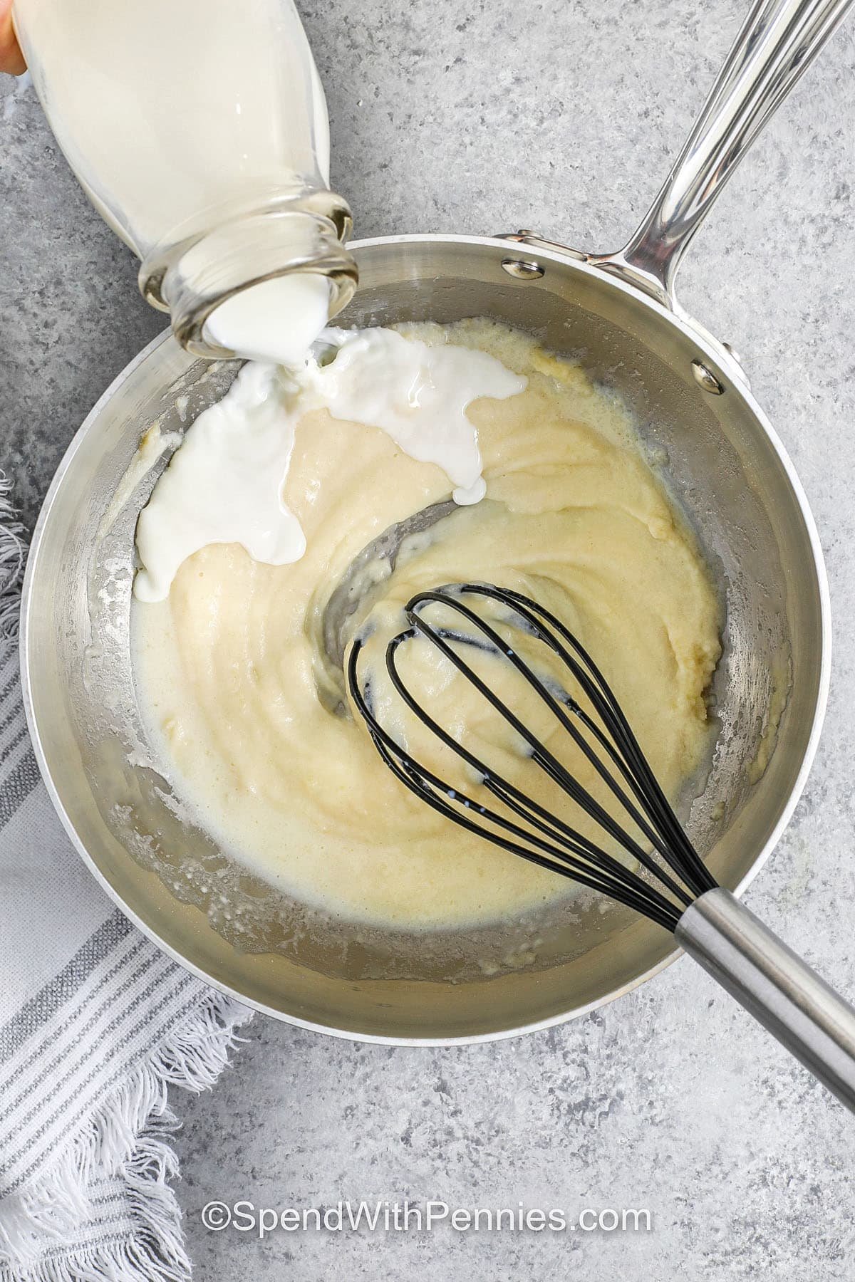 whisking milk into butter and flour mixture to make Bechamel