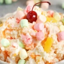 a bowl of ambrosia salad topped with a cherry