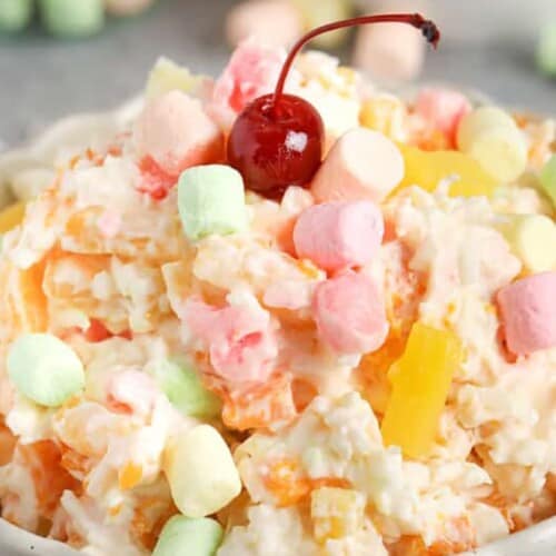 a bowl of ambrosia salad topped with a cherry